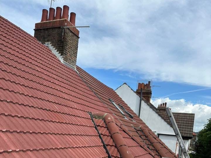 Re-tiled red roof with brick chimney and new lead flashing