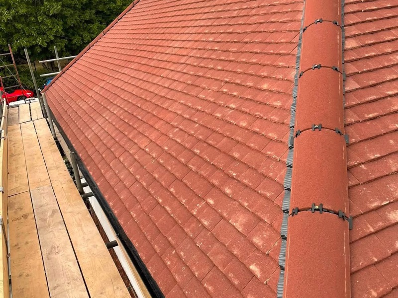 New red roof tiles with a dry-fix hip ridge, seen from the scaffold